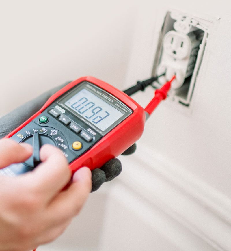 Electrician din București care folosește un aparat de măsură
